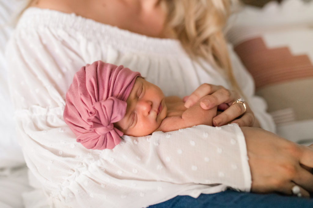 Mother holds baby girl during newborn session