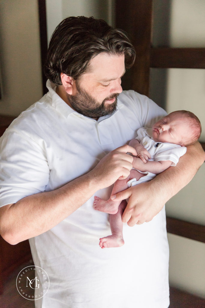 Father holding his newborn son during newborn lifestyle session