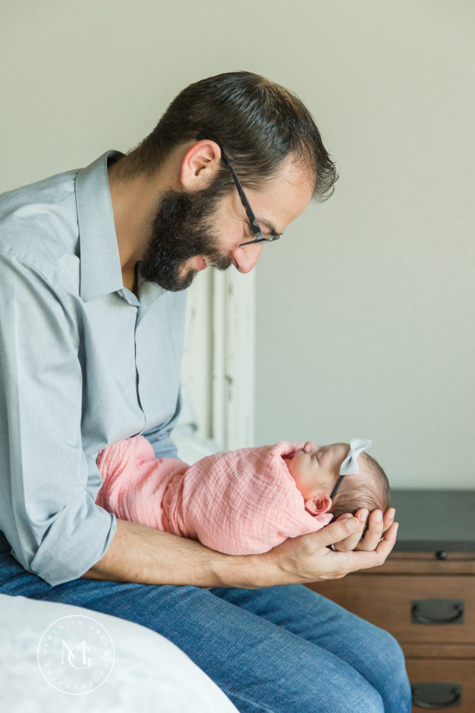 Dad holding baby girl during newborn lifestyle session