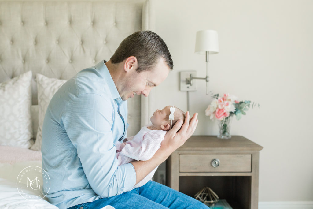 In home newborn session dad holding his baby girl