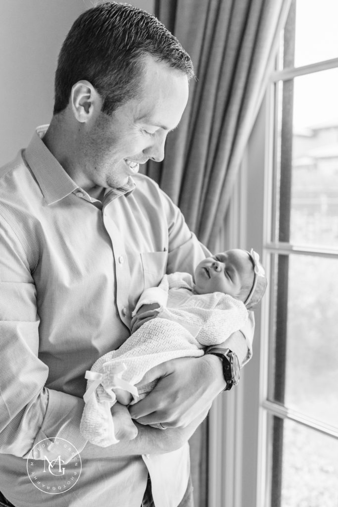 father holding his newborn daughter during an in home newborn session