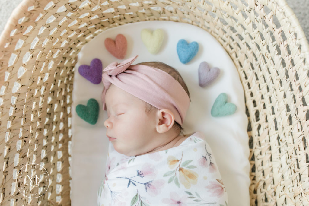Baby girl sleeping in a Moses basket during in home newborn session