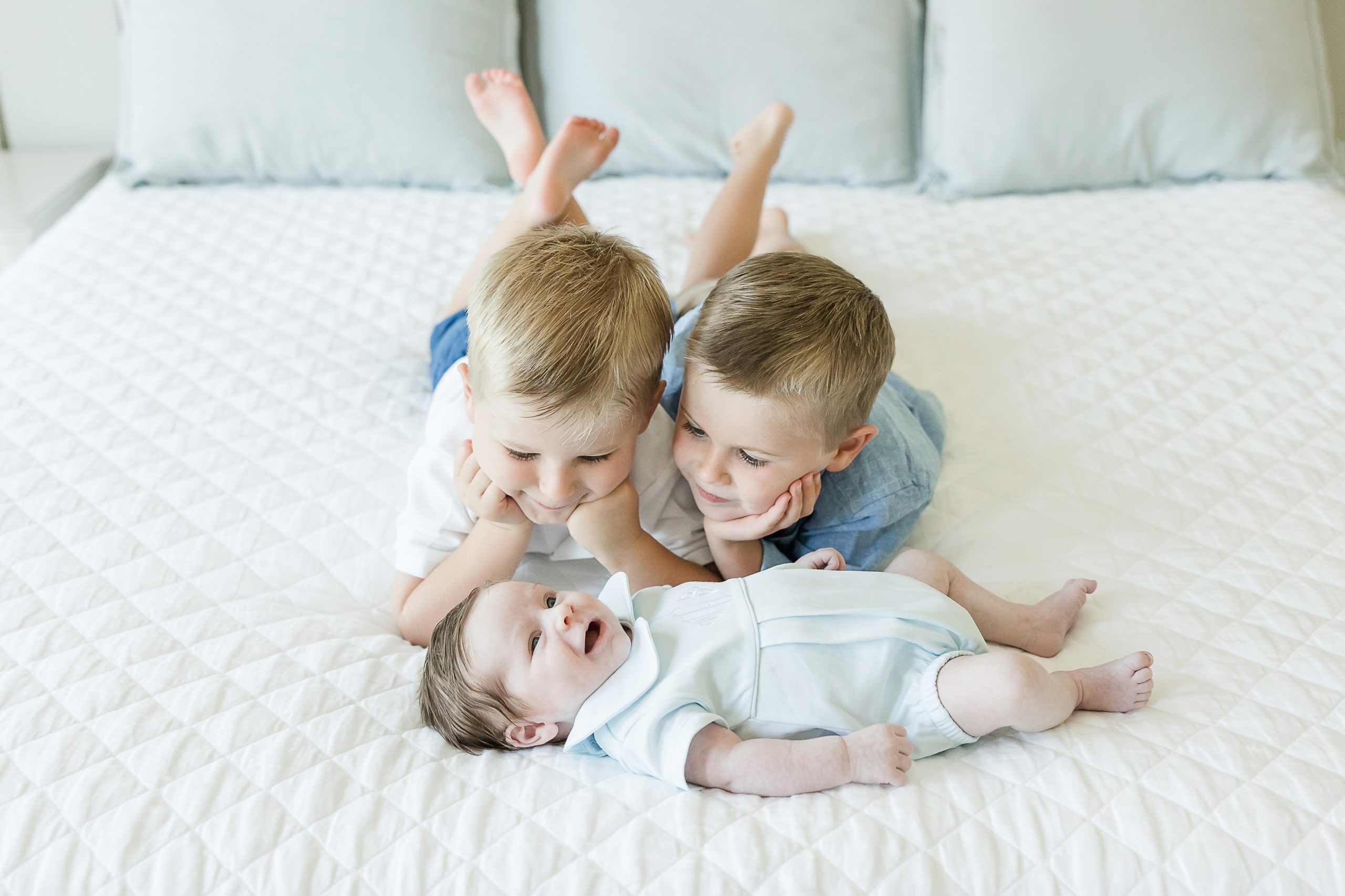 brothers with their baby brother at a newborn session at home