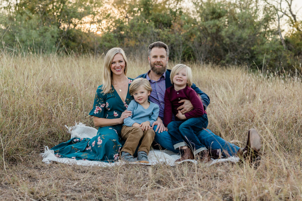 Bridges family sitting in field for fall family photos