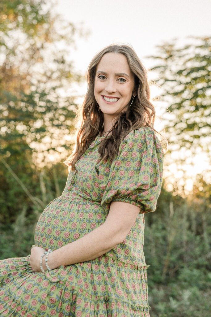 Mother wearing flowy dress smiling at camera