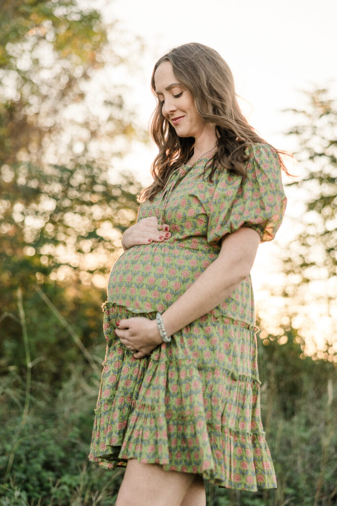 Mother wearing flowy dress holding her baby bump