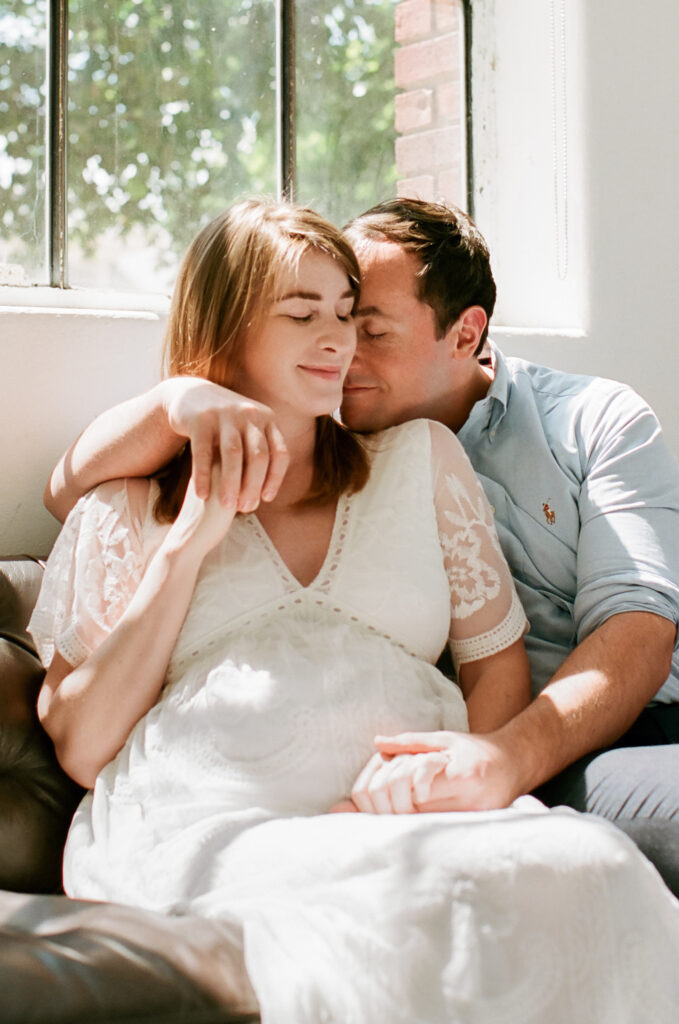 Couple cuddling on couch during photo shoot