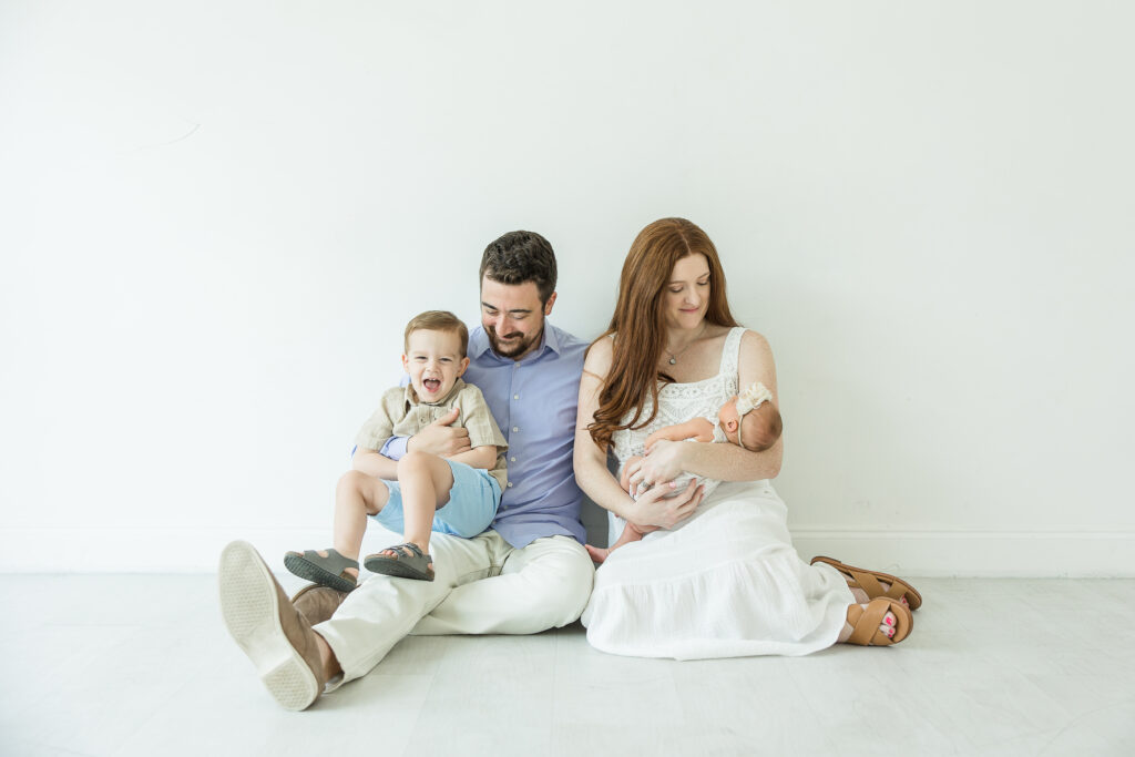 Family sitting on floor posing for family picture