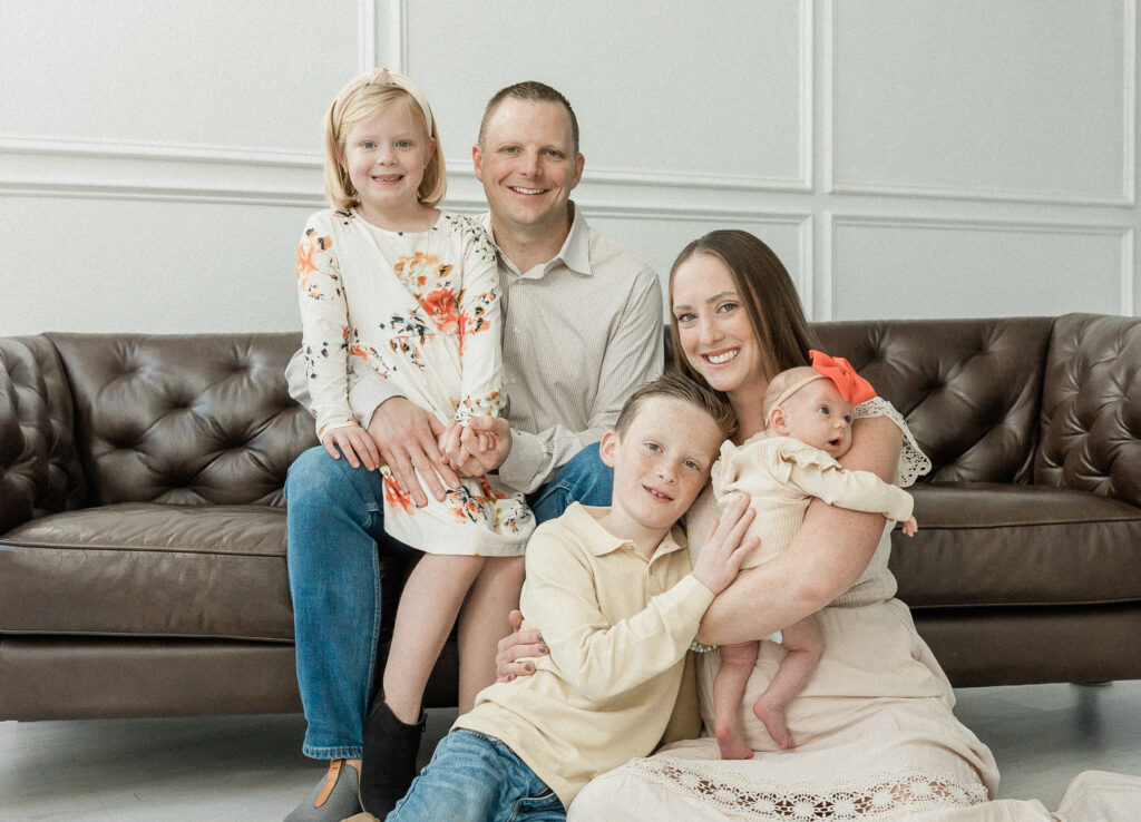 Family of five posing for family photo in studio